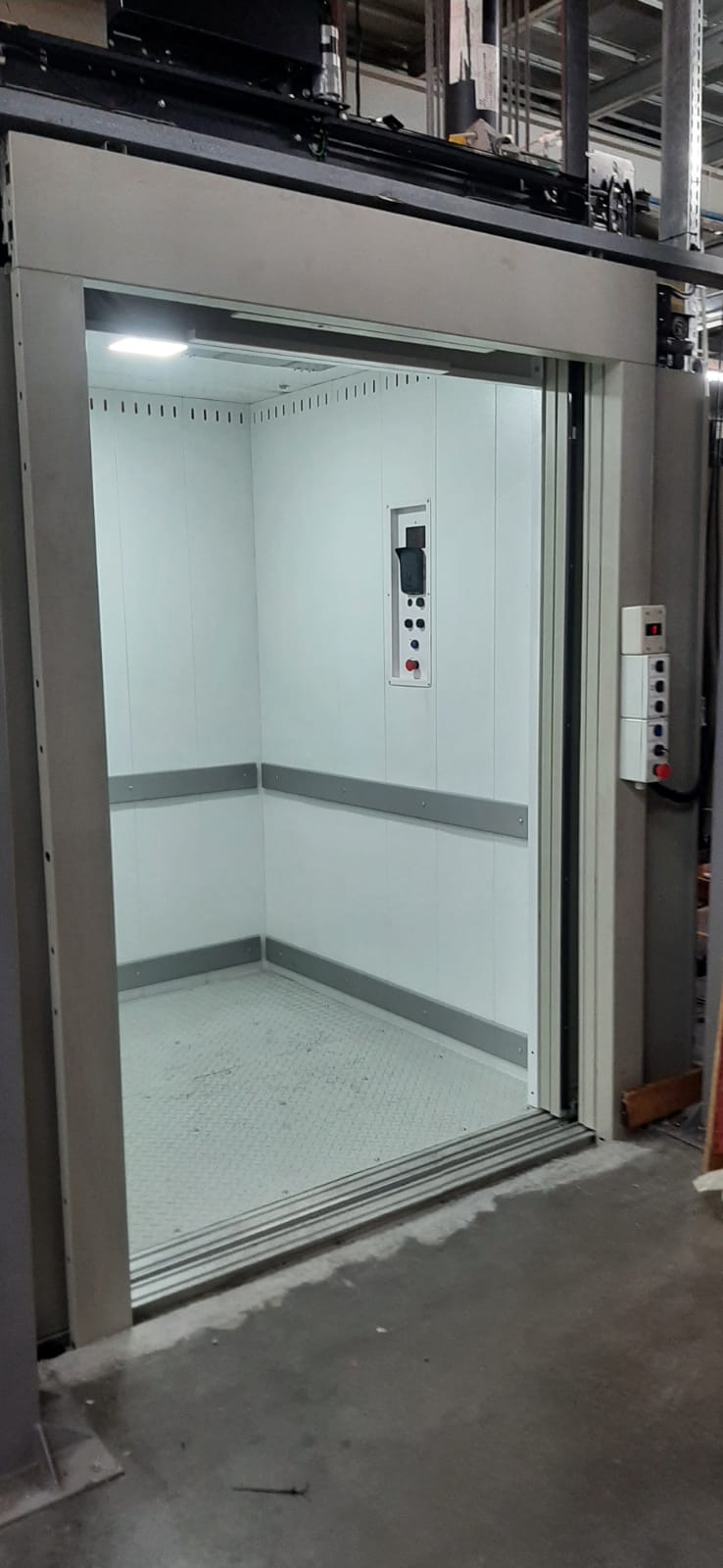 Elevador moderno com indicativo de manutenção em dia